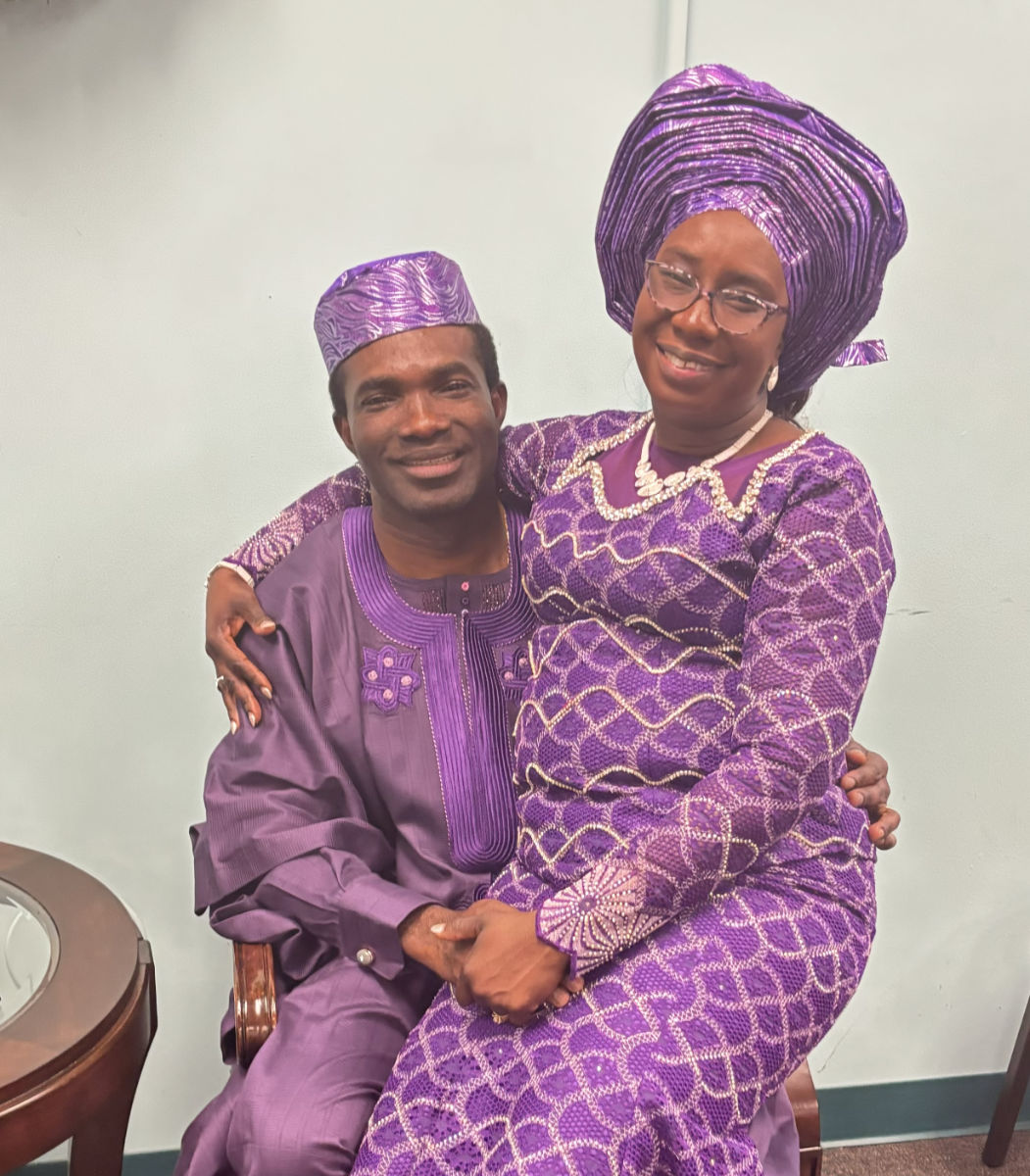 Photo of RCCG Pastor and Mrs Itebe. Mrs Itebe sitting on her husband's lap