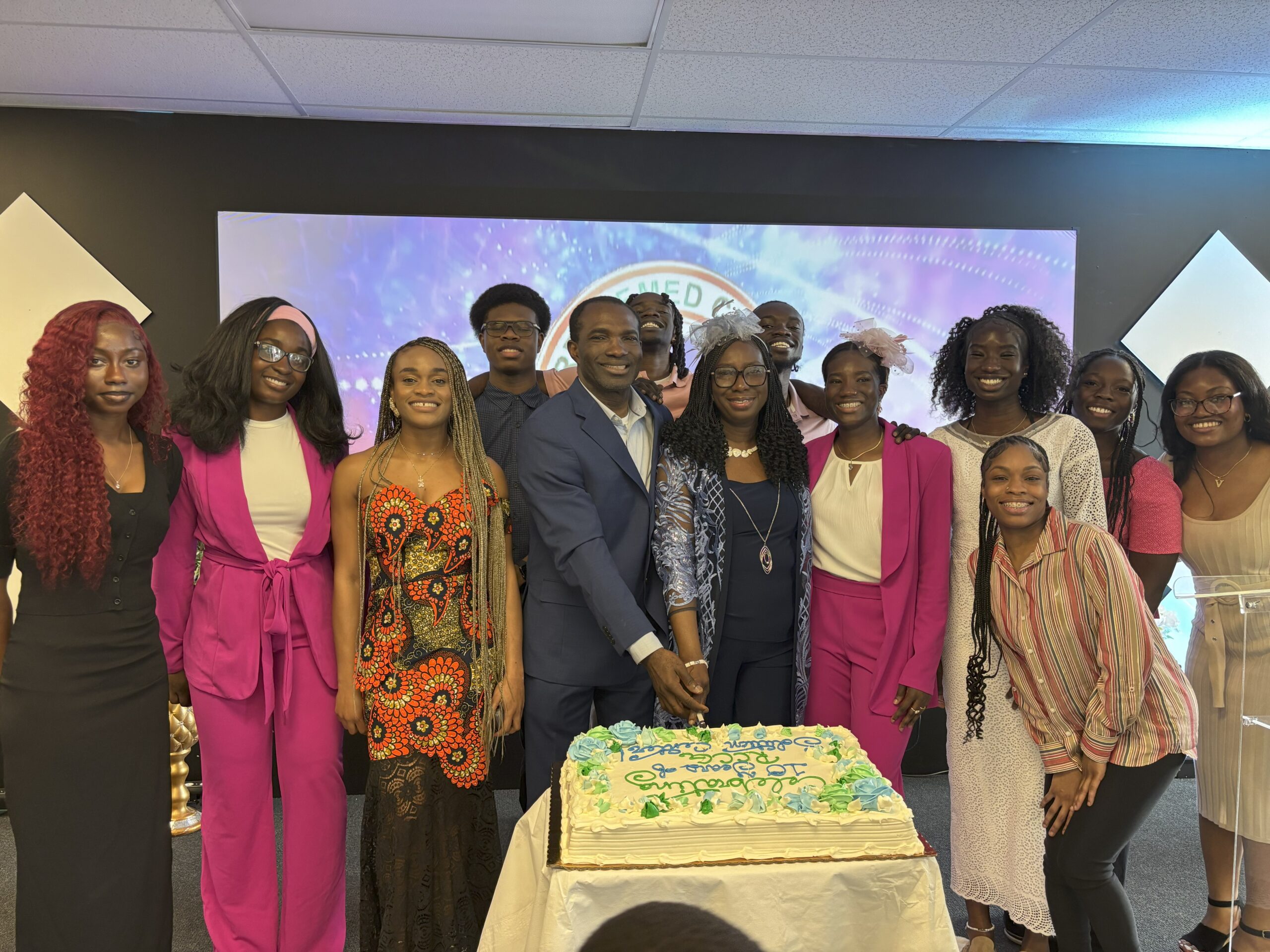 Solution center youths with pastor and his wife cutting a cake in celebration of the church's 10th year anniversary